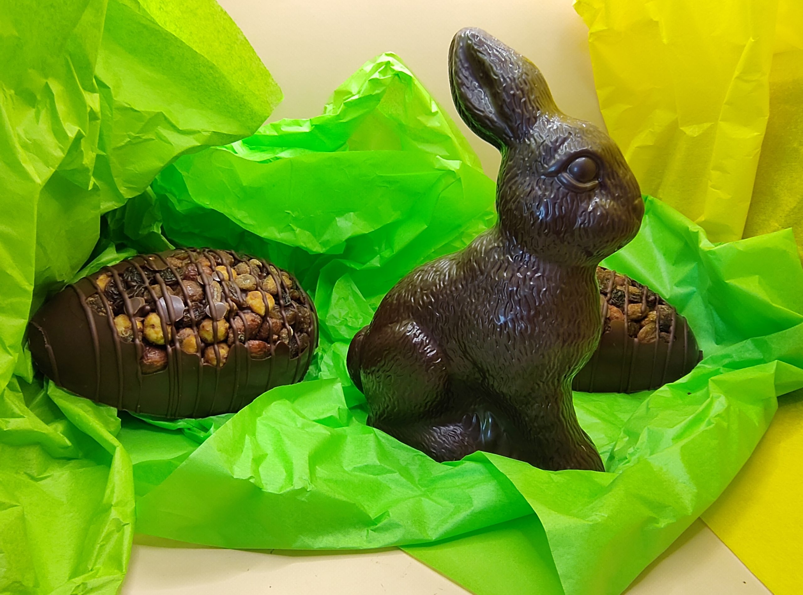 Un lapin assis au milieu d'oeufs en chocolat